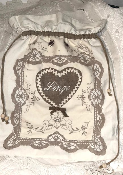 Grand sac à linge brodé écru.